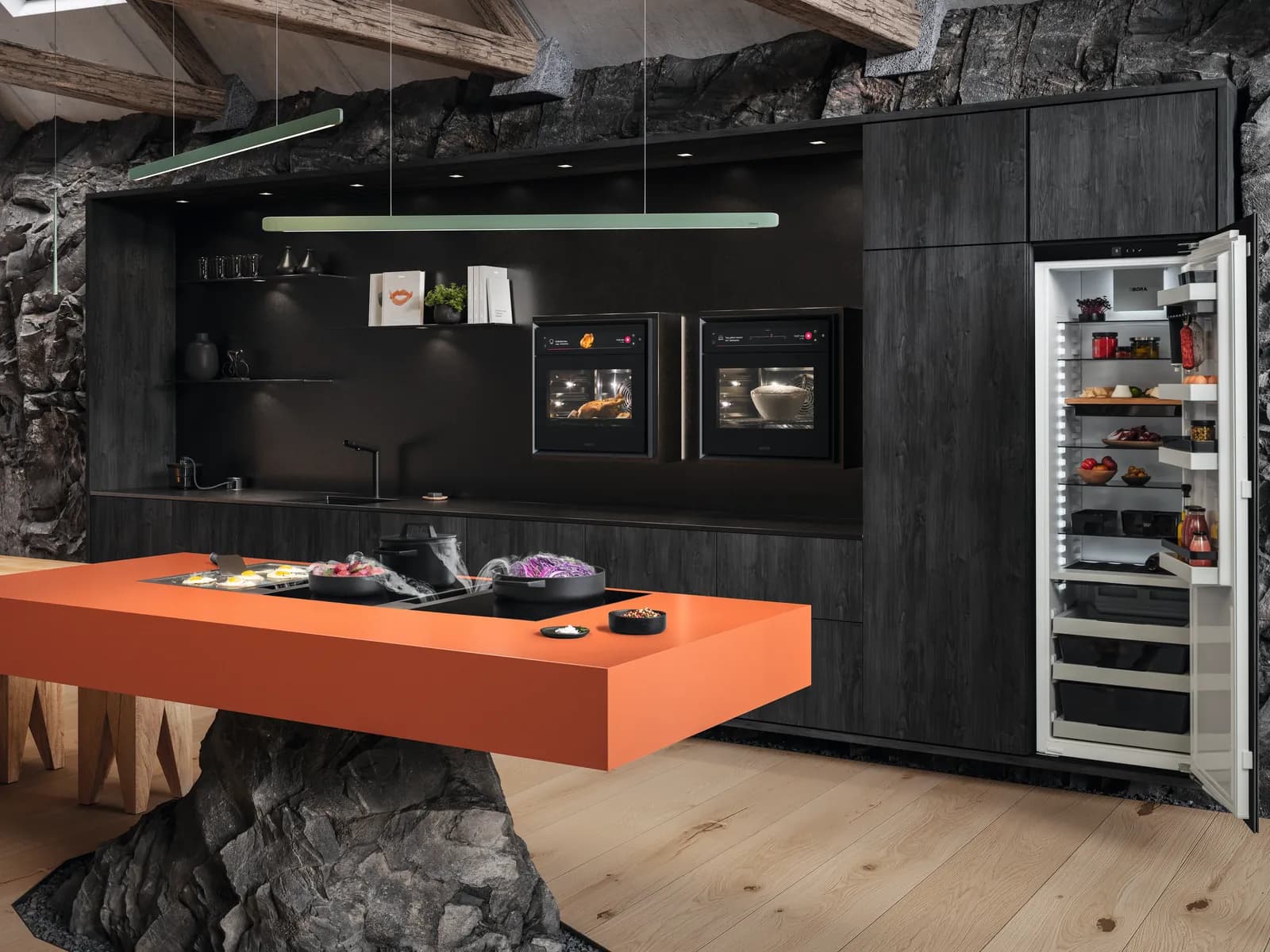 Dunkle Küche mit oranger Kochinsel und BORA Kochfeld, zwei BORA X BO in der Schrankwand und geöffnetem BORA Kühlschrank