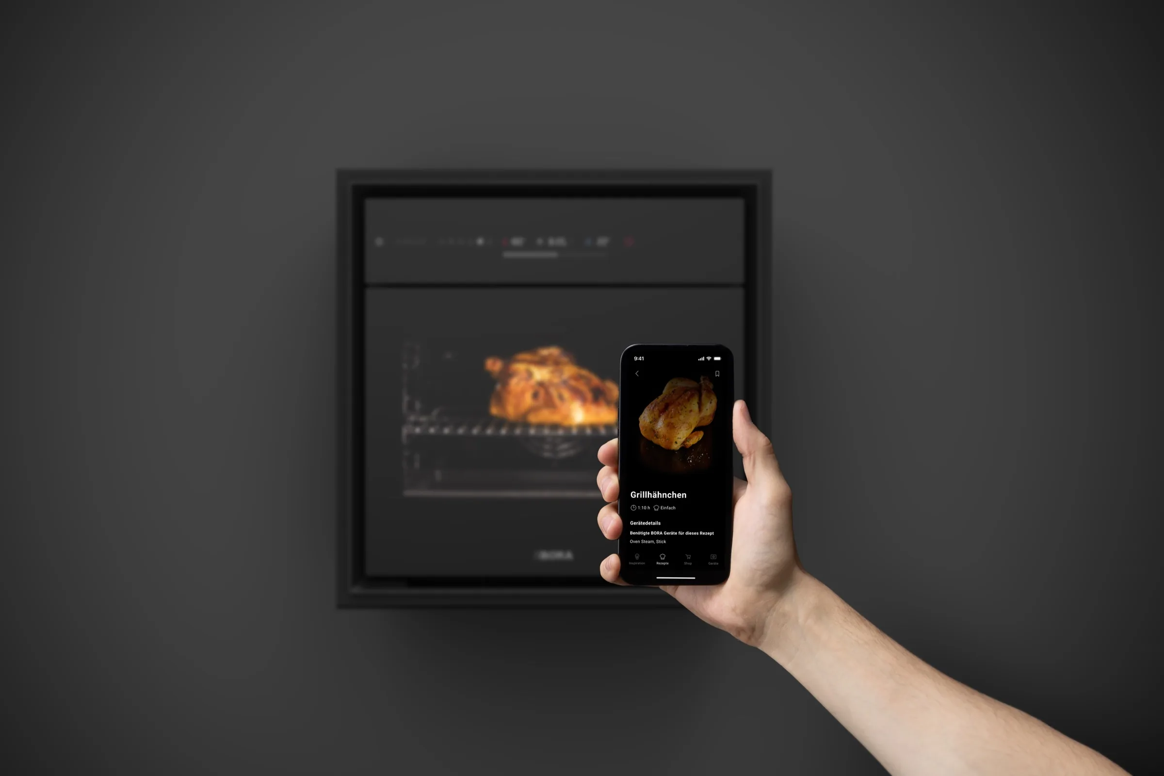 BORA Oven Steam mit Grillhähnchen im Garraum, davor ein Smartphone mit der BORA App